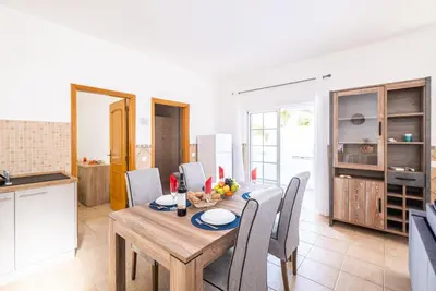 a kitchen and dining room with a wooden table and chairs at Villa Bahia by Algarve Vacation in Albufeira