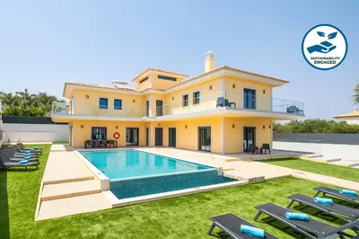 a villa with a swimming pool in front of a house at Villa Coral Bay by Algarve Vacation in Albufeira