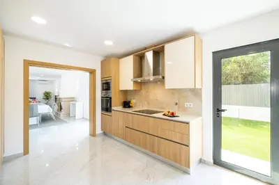 a kitchen with wooden cabinets and a large window at Villa Coral Bay by Algarve Vacation in Albufeira