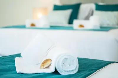 a pile of white towels sitting on top of a bed at Villa Coral Bay by Algarve Vacation in Albufeira