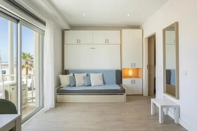a kitchen and dining room with white cabinets and a table at Centralgarve - Stunning Beach Front Studio - Astro in Quarteira