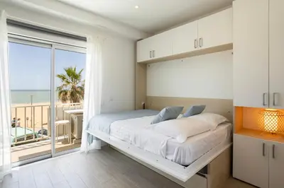 a bedroom with a bed and a balcony with the ocean at Centralgarve - Stunning Beach Front Studio - Astro in Quarteira