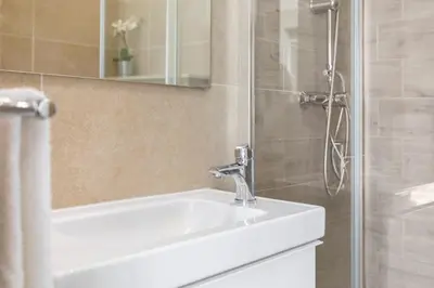 a bathroom with a white sink and a shower at Centralgarve - Stunning Beach Front Studio - Astro in Quarteira