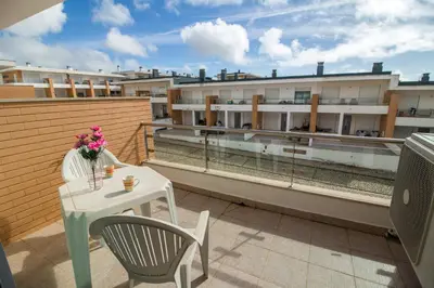 a balcony with a table and chairs and buildings at Albufeira Stylish Townhouse in Albufeira