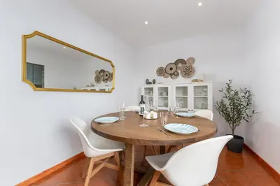 a dining room table with white chairs and a mirror at Casa dos Sonhos Albufeira in Albufeira