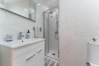 a white bathroom with a shower and a sink at Casa dos Sonhos Albufeira in Albufeira