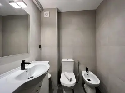 a bathroom with a sink and a toilet and a mirror at Albufeira Downtown With Pool by Homing in Albufeira