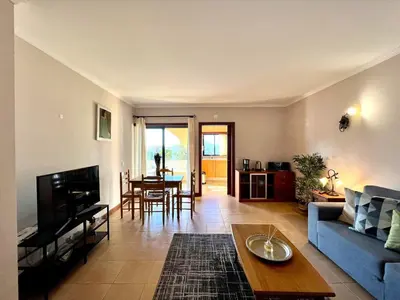 a living room with a blue couch and a table at Albufeira Salgados Beach 3 by Homing in Albufeira