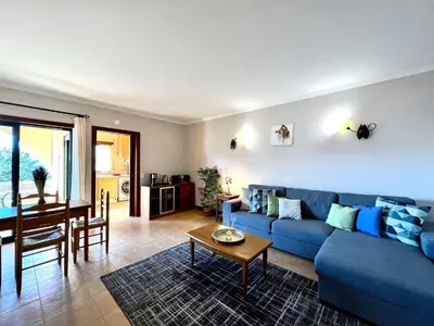 a living room with a blue couch and a table at Albufeira Salgados Beach 3 by Homing in Albufeira