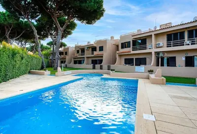 a swimming pool in front of a building at ALEGRIA 29 - T2 piso terreo com AC e piscina by My Algarve Rentals in Quarteira