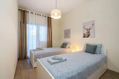 a bedroom with two beds and a window at ALEGRIA 29 - T2 piso terreo com AC e piscina by My Algarve Rentals in Quarteira