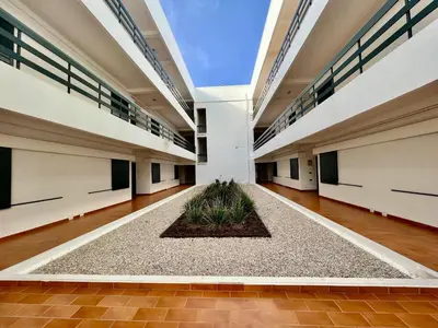 an empty hallway in a building with a plant in the middle at Vilamoura Central 4 With Pool by Homing in Vilamoura