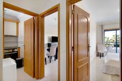 a hallway with a door leading to a kitchen and a dining room at Lovely one bedroom apartment in Quarteira