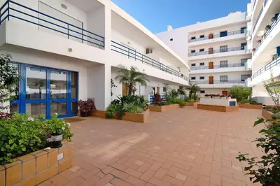 an empty courtyard of a building with plants at Lovely one bedroom apartment in Quarteira