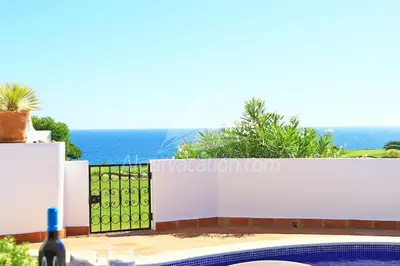 a white fence with the ocean in the background at Villa Seaside in Vale do Lobo