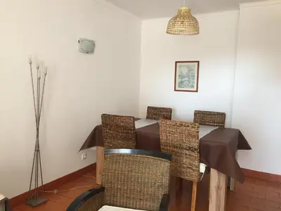 a dining room with a table and wicker chairs at Apartment 3 persons in Vilamoura, Algarve in Quarteira
