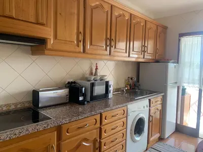 a kitchen with a microwave and a washer and dryer at Apartment 3 persons in Vilamoura, Algarve in Quarteira