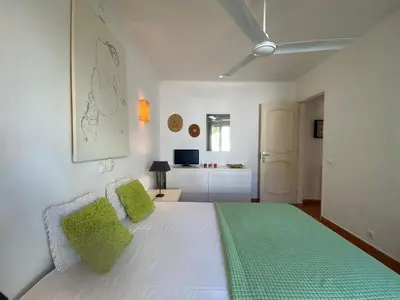 a white bed with green pillows in a bedroom at Aldeia do Golf O7 in Quarteira