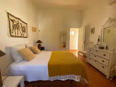 a bedroom with a large white bed and a dresser at Aldeia do Golf O7 in Quarteira