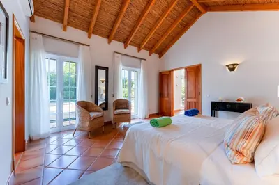 a bedroom with a large bed in a room with windows at Villa Breena - Quinta do Mar in Almancil