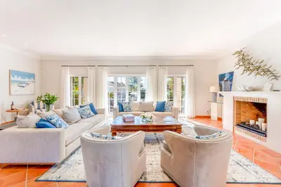 a living room with white furniture and a fireplace at Villa Breena - Quinta do Mar in Almancil