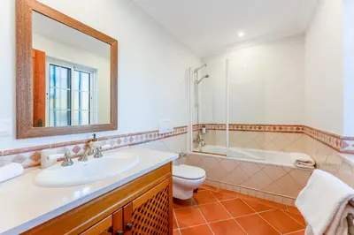 a bathroom with a sink and a toilet and a mirror at Villa Breena - Quinta do Mar in Almancil