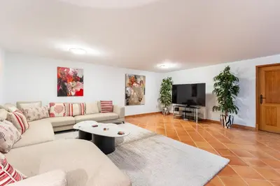 a living room with a couch and a tv at Villa Breena - Quinta do Mar in Almancil