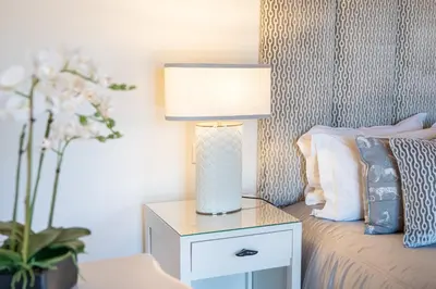 a lamp on a night stand next to a bed at Villa Breena - Quinta do Mar in Almancil