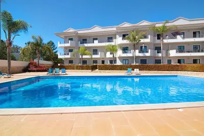 a large swimming pool in front of a building at Apartamento T1 - Em zona tranquila in Olhos de Água