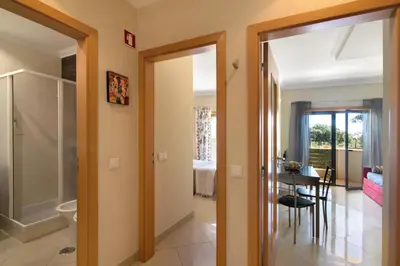 a hallway with a door open to a room with a table at Apartamento T1 - Em zona tranquila in Olhos de Água
