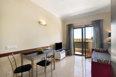 a living room with a table and a room with a couch at Apartamento T1 - Em zona tranquila in Olhos de Água