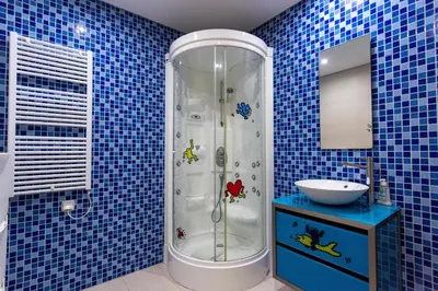 a blue tiled bathroom with a shower and a sink at Marina Vilamoura - Aquamar 006 By Vilamoura Sun in Vilamoura