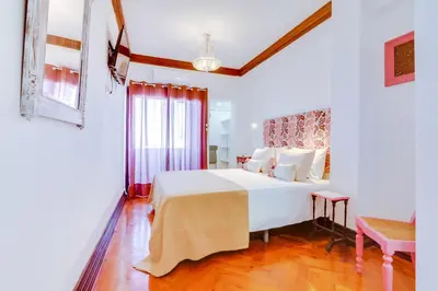 a bedroom with a large white bed in a room at À dos Reis in Faro