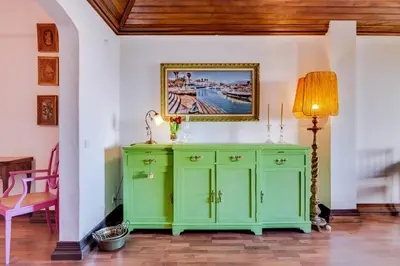 a green cabinet in a room with a lamp at À dos Reis in Faro