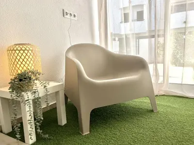 a white chair sitting next to a table and a window at Sun II - City center by HD PROPERTIES in Vilamoura