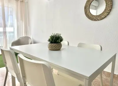 a white dining room table with white chairs and a potted plant at Sun II - City center by HD PROPERTIES in Vilamoura