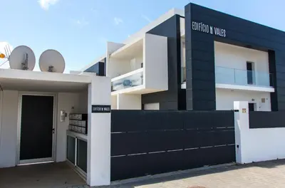 a black and white building with a black fence at By the sea, Algarve in Galé