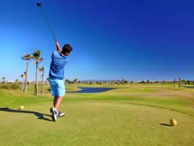 a man swinging a golf club on a golf course at Luxury Penthouse Apartment Private Jacuzzi, Albufeira in Albufeira
