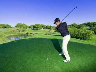 a woman swinging a golf club on a golf course at Luxury Penthouse Apartment Private Jacuzzi, Albufeira in Albufeira