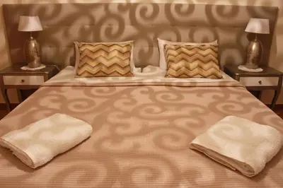a large bed with two pillows on it with two lamps at Apartment Amelo in Albufeira