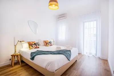 a white bedroom with a large bed and a mirror at Villa Amaris by Atlantic Places in Albufeira