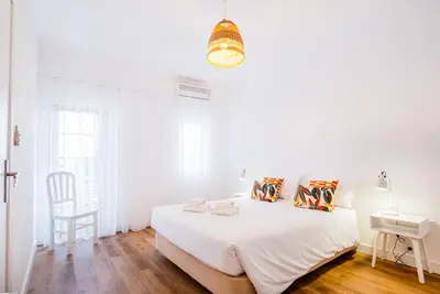 a white bedroom with a bed and a chair at Villa Amaris by Atlantic Places in Albufeira