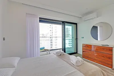 a bedroom with a bed and a mirror and a window at Sky Beach Apartment in Quarteira