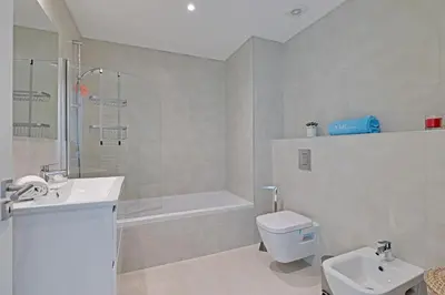a bathroom with a sink and a toilet and a bath tub at Sky Beach Apartment in Quarteira