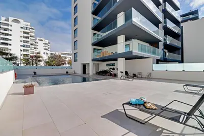 an image of a building with a swimming pool at Sky Beach Apartment in Quarteira
