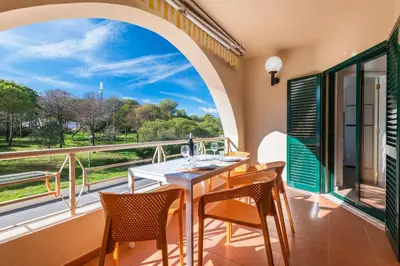 a dining room with a table and chairs on a balcony at Salgados 1 Bedroom Apartment - 500m from the Beach in Guia