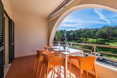 a balcony with a table and chairs and a large window at Salgados 1 Bedroom Apartment - 500m from the Beach in Guia