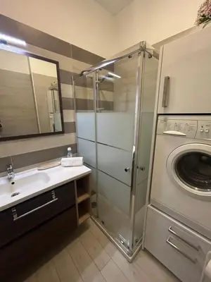 a bathroom with a sink and a washing machine at Casa Garcia in Quarteira
