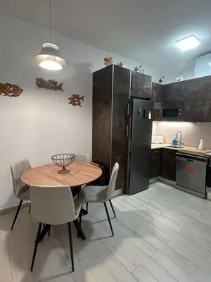 a kitchen with a table and chairs and a refrigerator at Casa Garcia in Quarteira