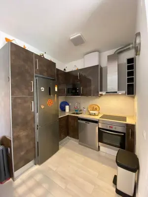 a kitchen with stainless steel appliances and wooden cabinets at Casa Garcia in Quarteira